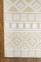 Geometric patterned rug in beige and cream with tribal diamond motifs