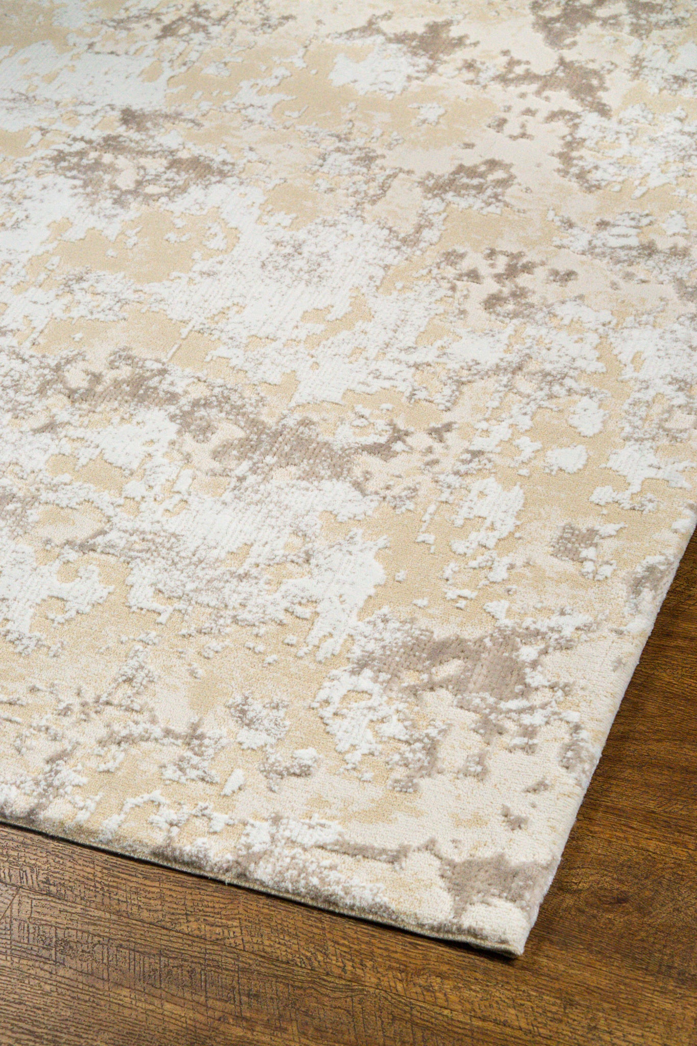 Distressed beige and cream textured rug with mottled vintage pattern