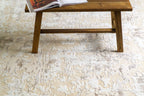 Distressed beige and cream textured rug with mottled vintage pattern