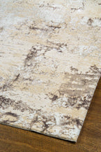 Distressed beige and gray textured rug with mottled vintage pattern