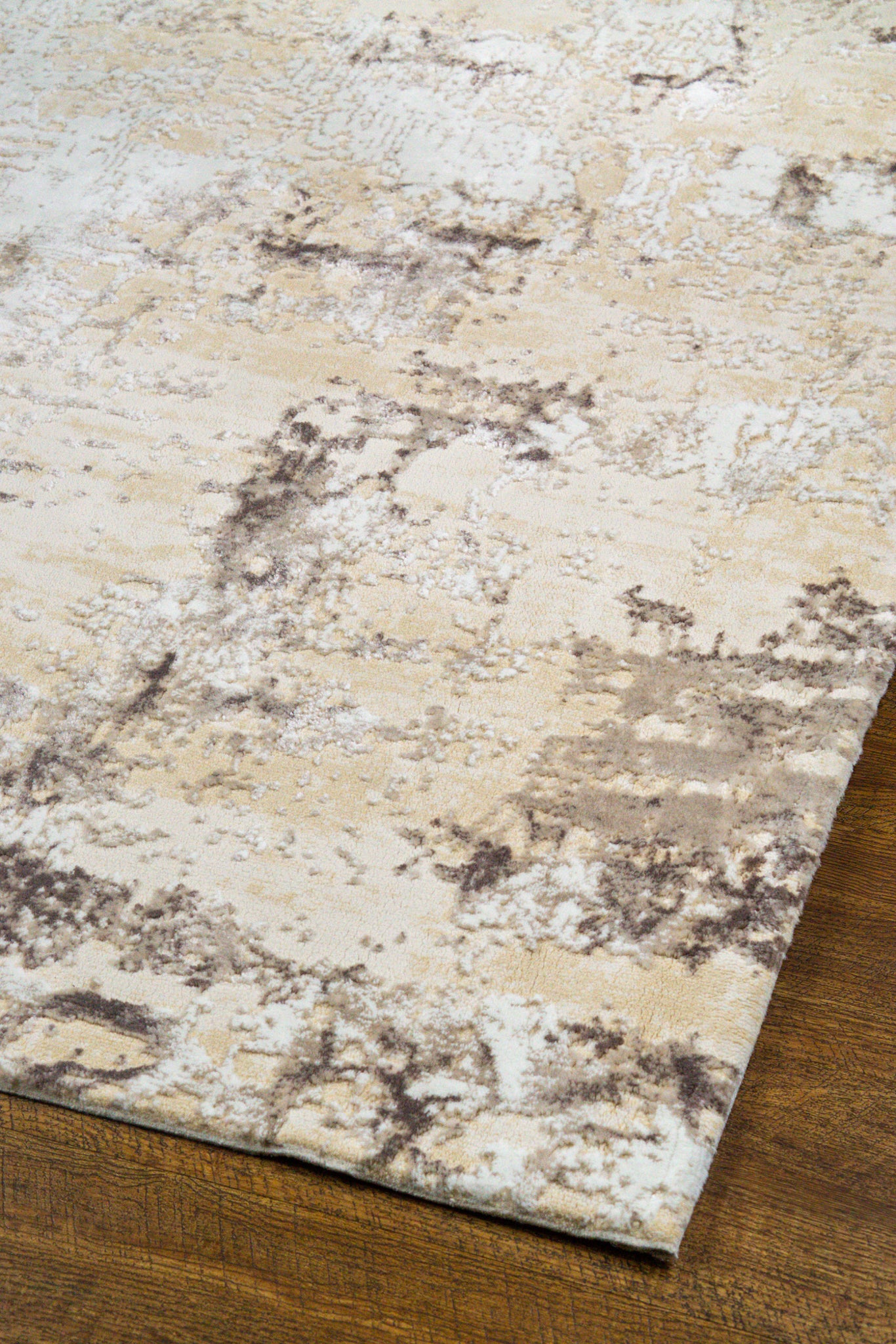 Distressed beige and gray textured rug with mottled vintage pattern