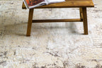 Distressed beige and gray textured rug with mottled vintage pattern