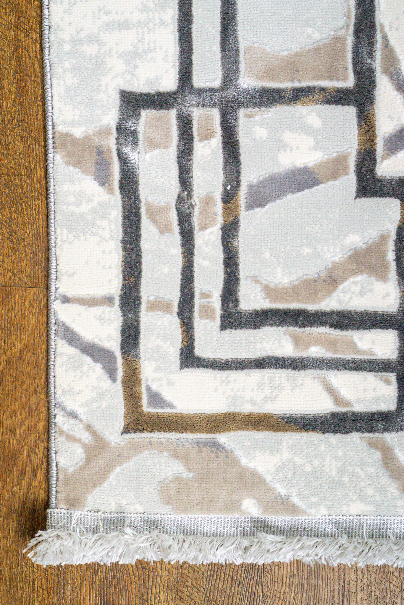 Cream and taupe abstract geometric rug with linear patterns and distressed finish