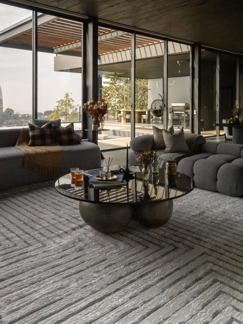Modern geometric rug with nested square pattern in grey and cream tones
