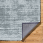 Light blue textured area rug with subtle grey distressed pattern and worn finish
