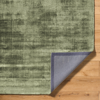 Modern distressed green wool rug with abstract texture and mottled pattern
