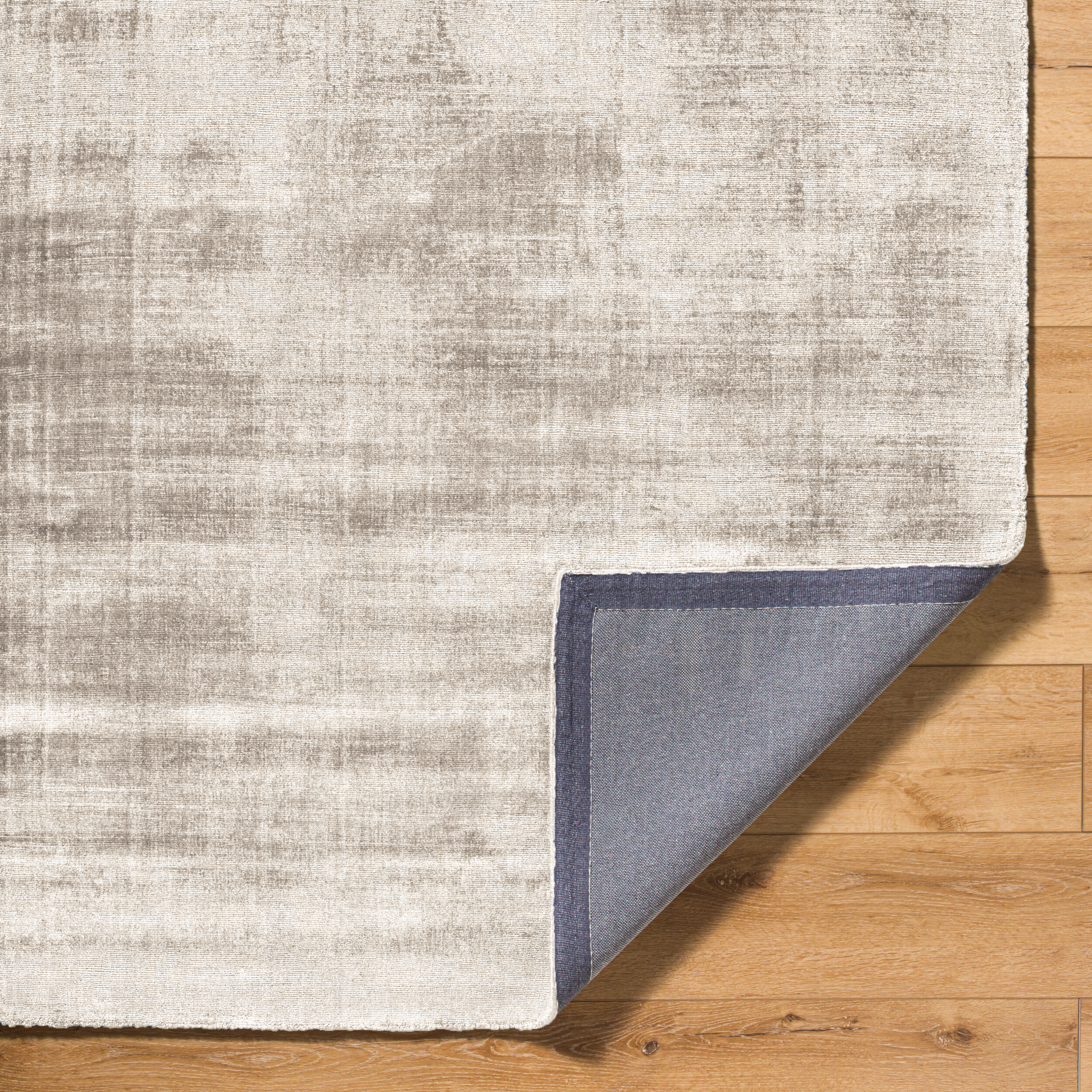 Cream and grey distressed textured rug with mottled abstract pattern