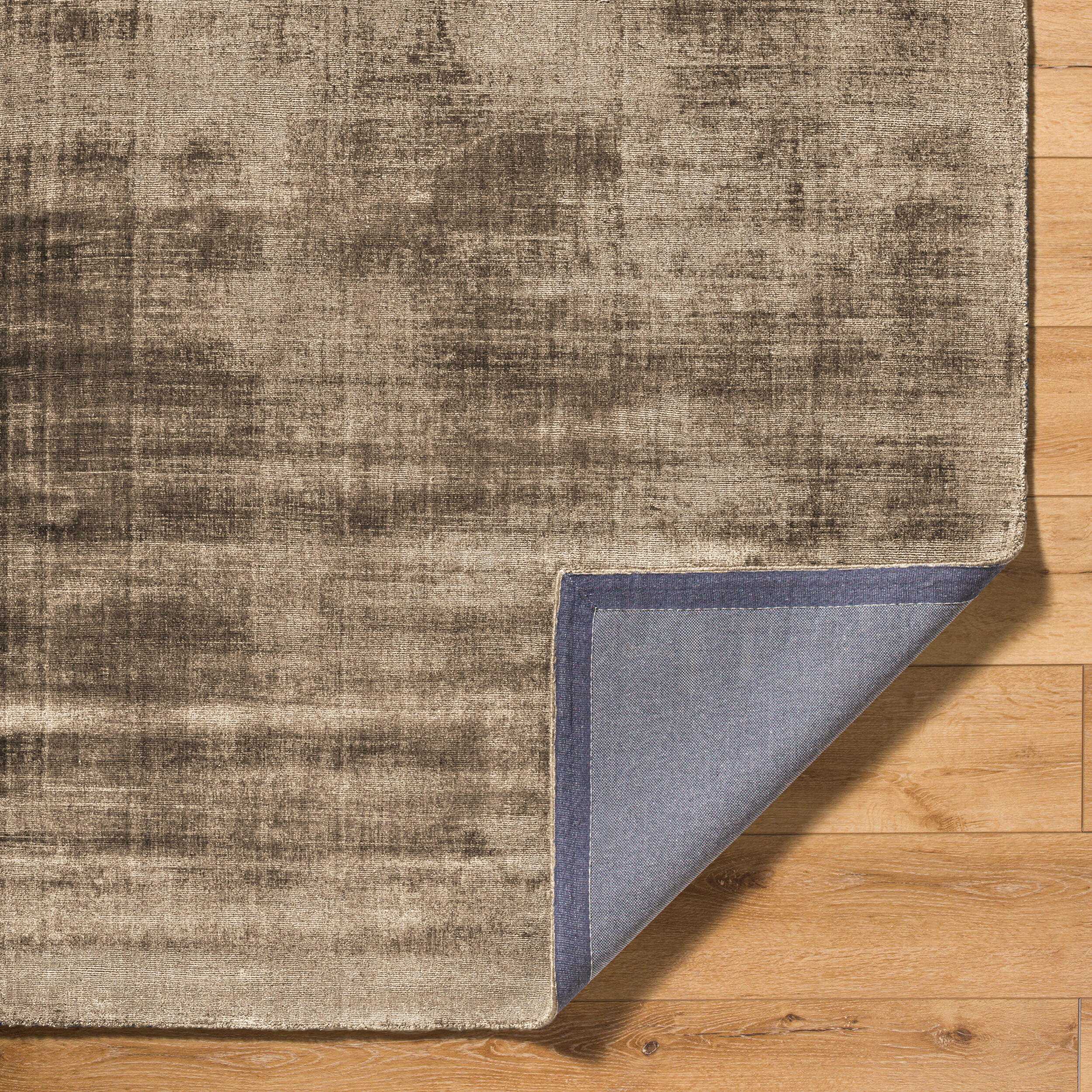 Beige distressed area rug with abstract dark streaks and worn texture throughout