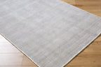 Neutral grey woven rug with subtle textured pattern and fringed edges