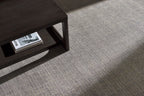 Neutral grey woven rug with subtle textured pattern and fringed edges