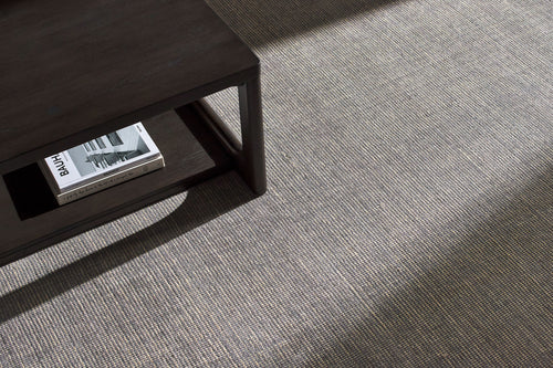 Neutral grey woven rug with subtle textured pattern and fringed edges