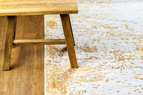 Gold and cream distressed texture rug with abstract weathered pattern