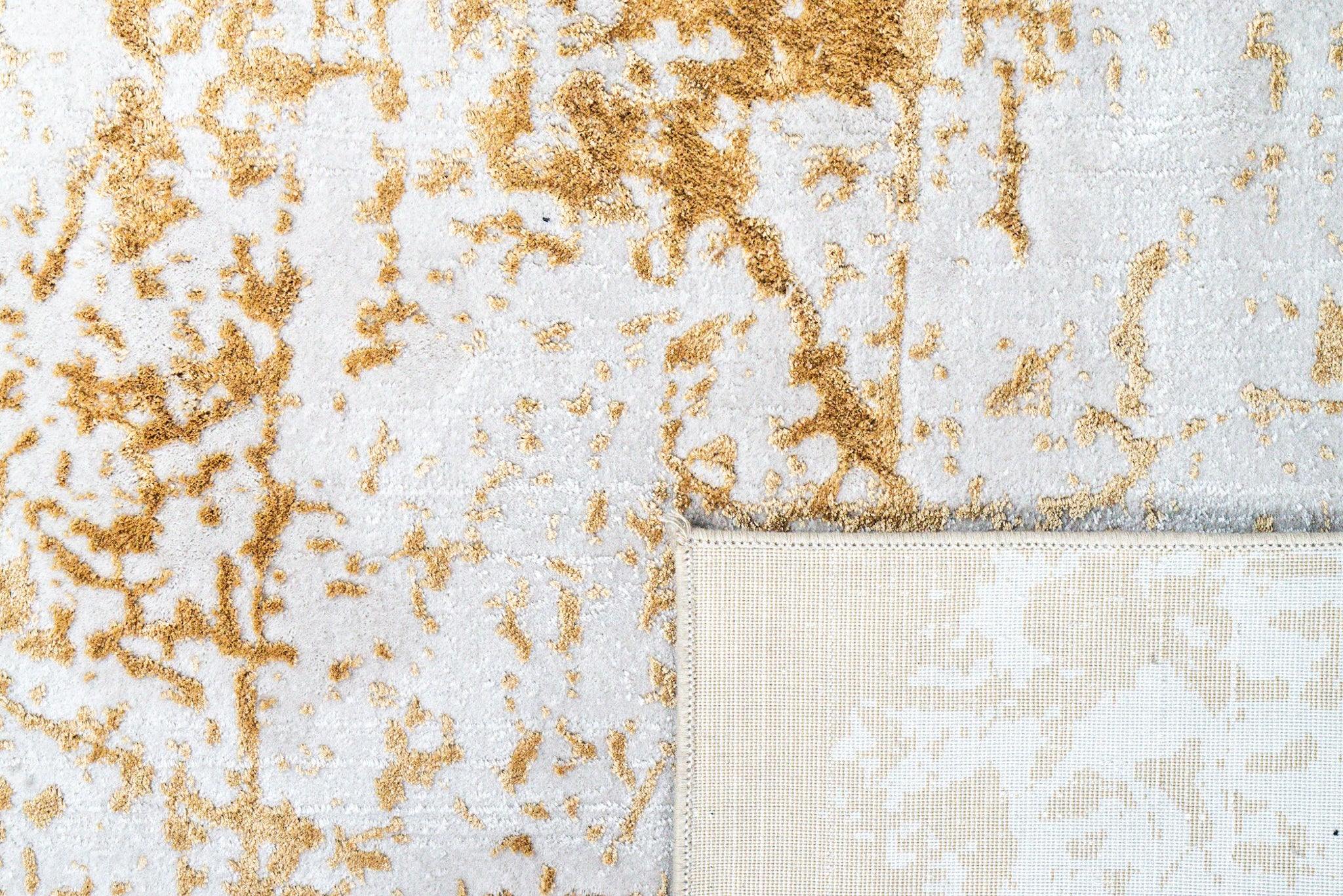 Gold and cream distressed texture rug with abstract weathered pattern
