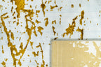 Distressed white and gold rug with splattered paint effect texture