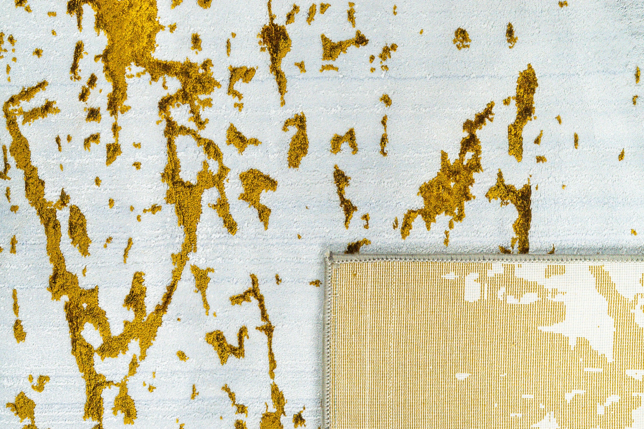 Distressed white and gold rug with splattered paint effect texture