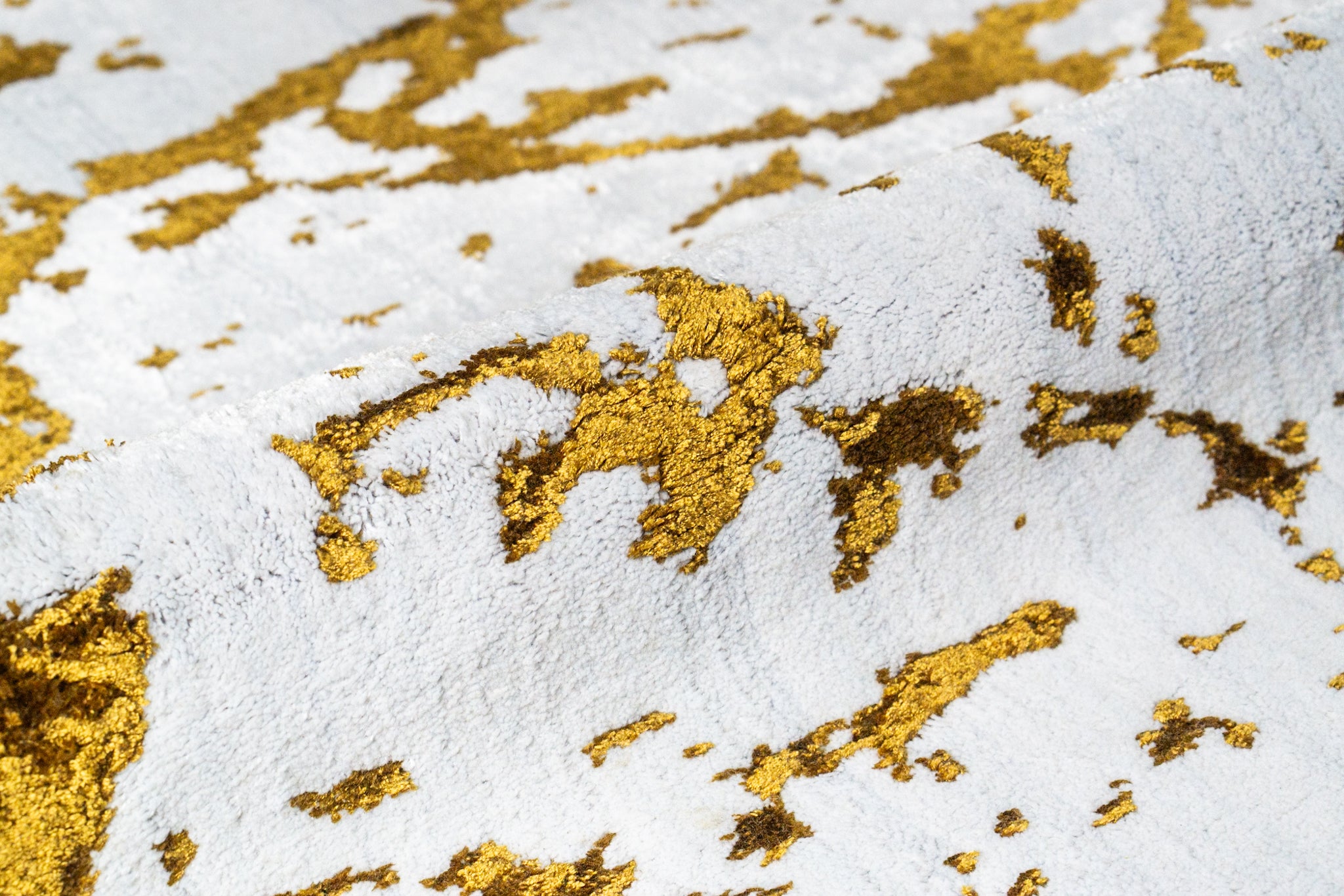 Distressed white and gold rug with splattered paint effect texture