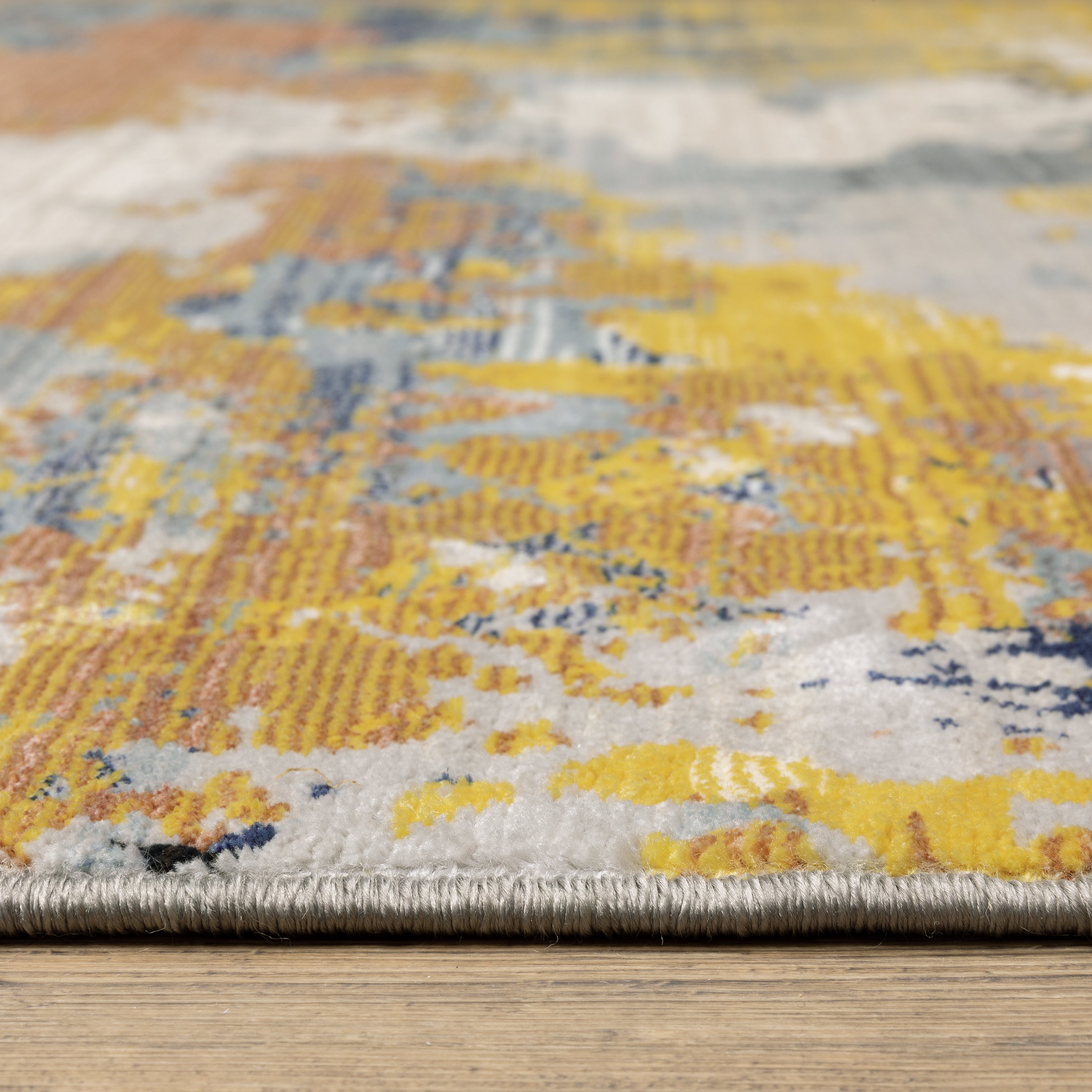 Abstract distressed rug with yellow, blue, and cream paint splatter pattern design