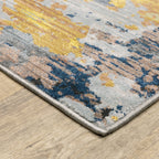 Abstract distressed rug with yellow, blue, and cream paint splatter pattern design