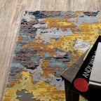 Abstract distressed rug with yellow, blue, and cream paint splatter pattern design