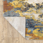 Abstract distressed rug with yellow, blue, and cream paint splatter pattern design