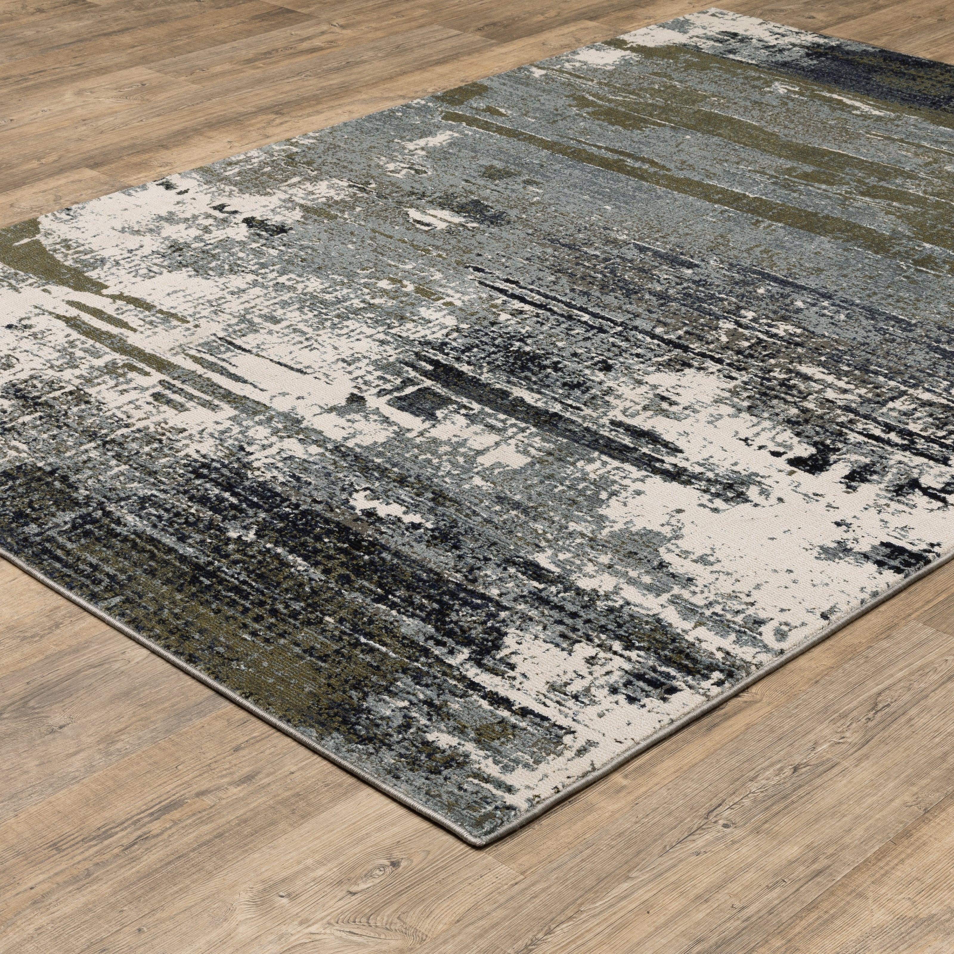 Abstract distressed area rug with grey, olive, and cream mottled texture pattern