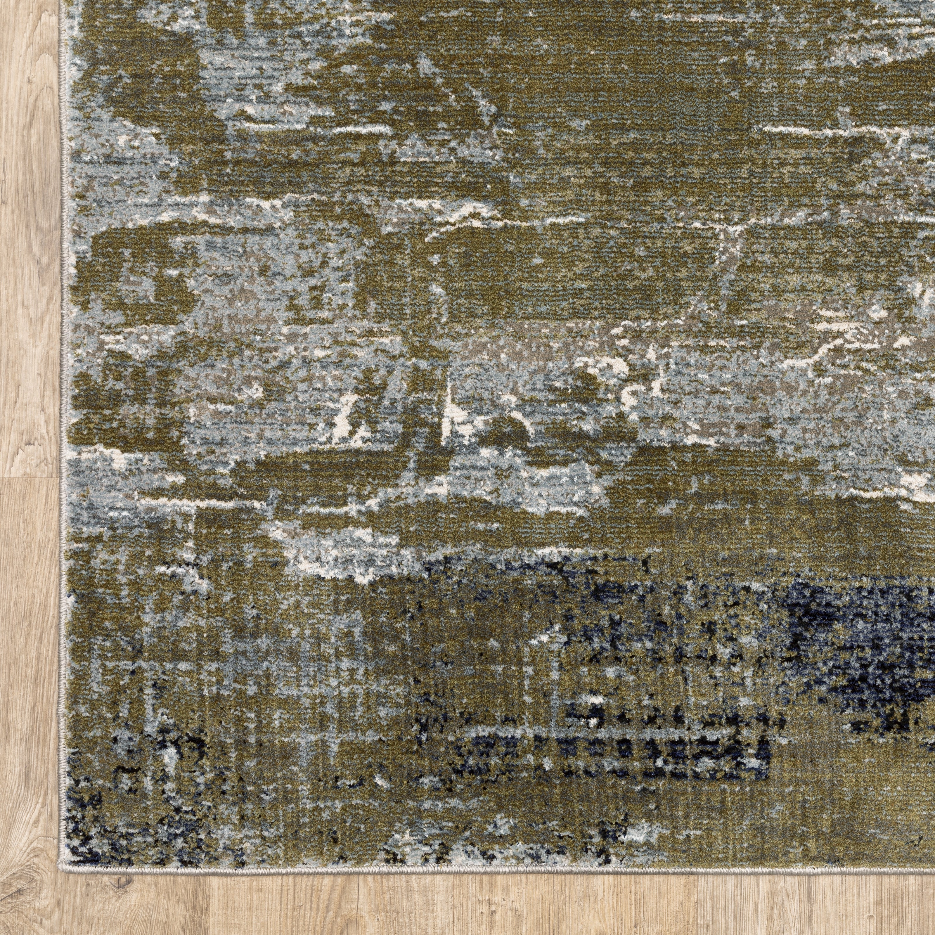 Abstract distressed area rug with grey, olive, and cream mottled texture pattern