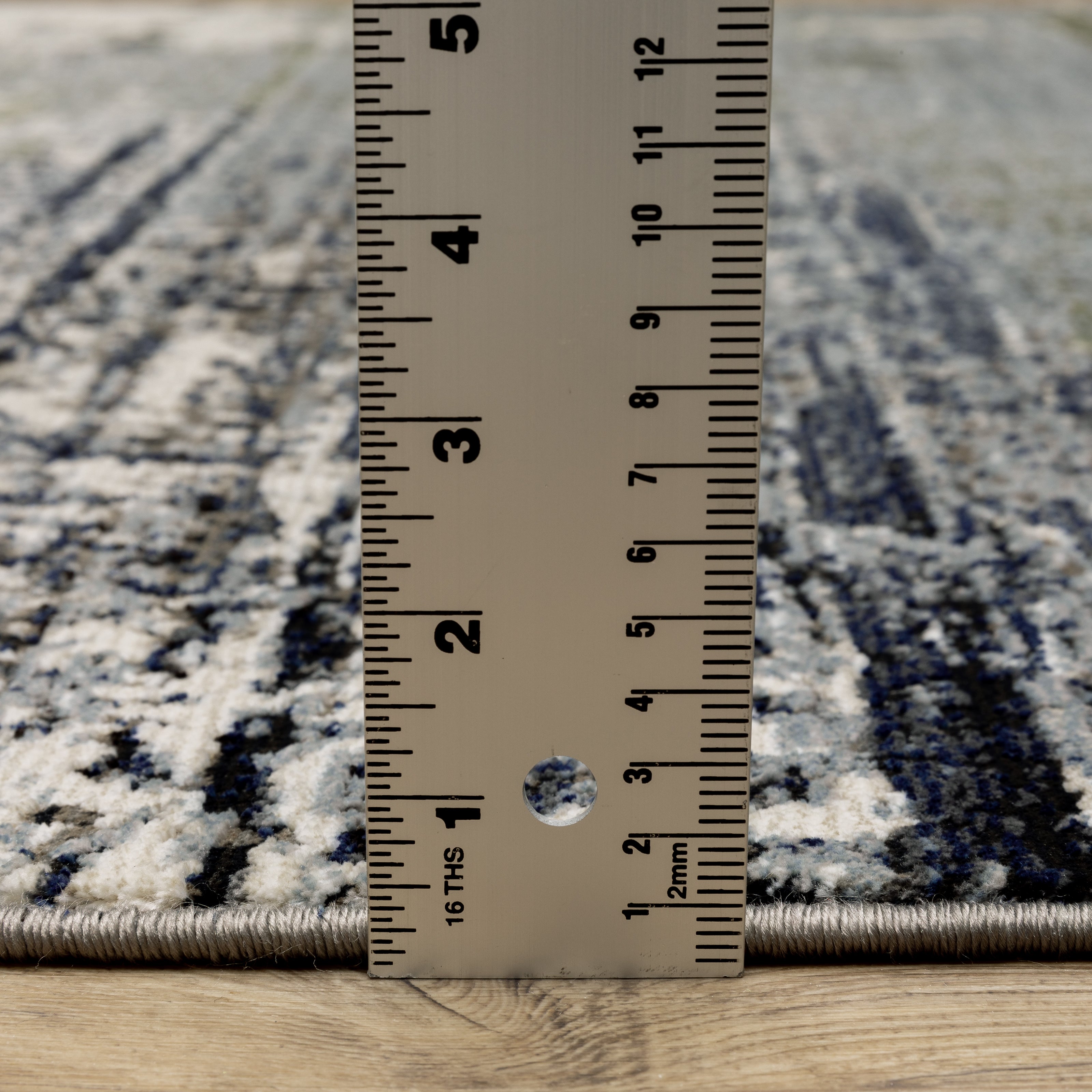 Abstract distressed area rug with grey, olive, and cream mottled texture pattern