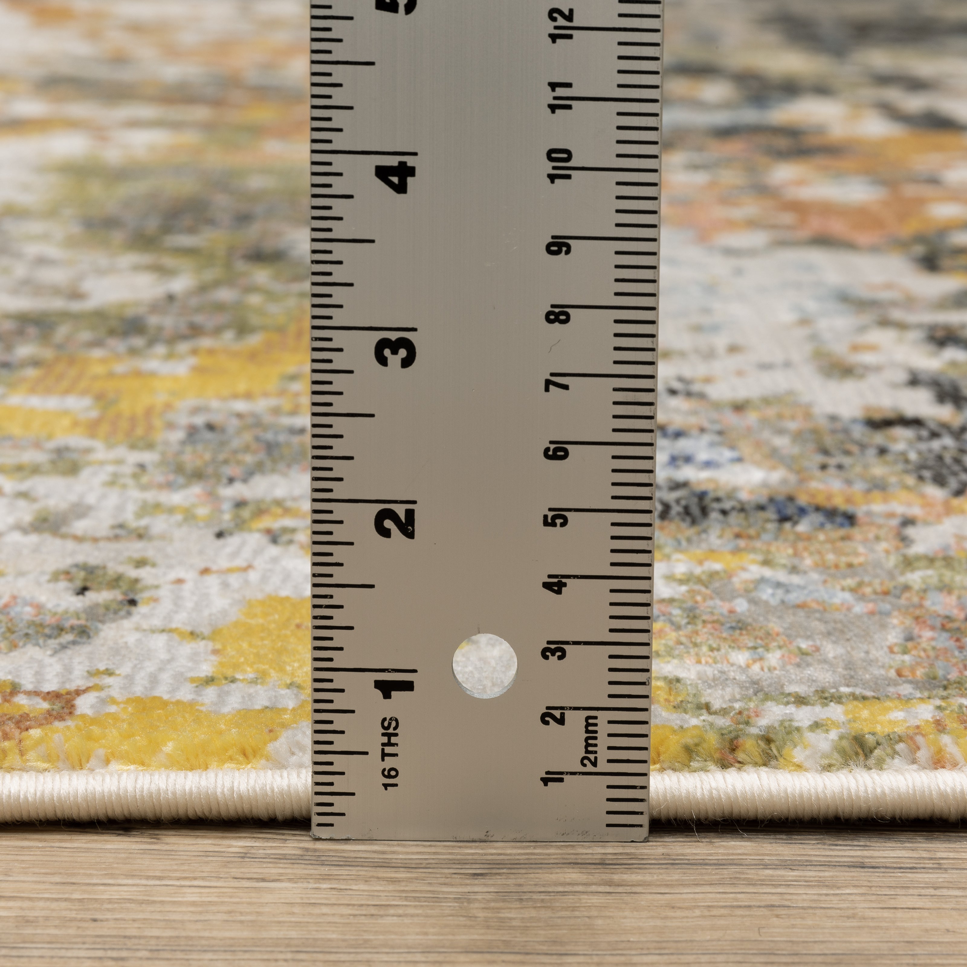 Modern abstract area rug with distressed gold, gray, and blue speckled pattern