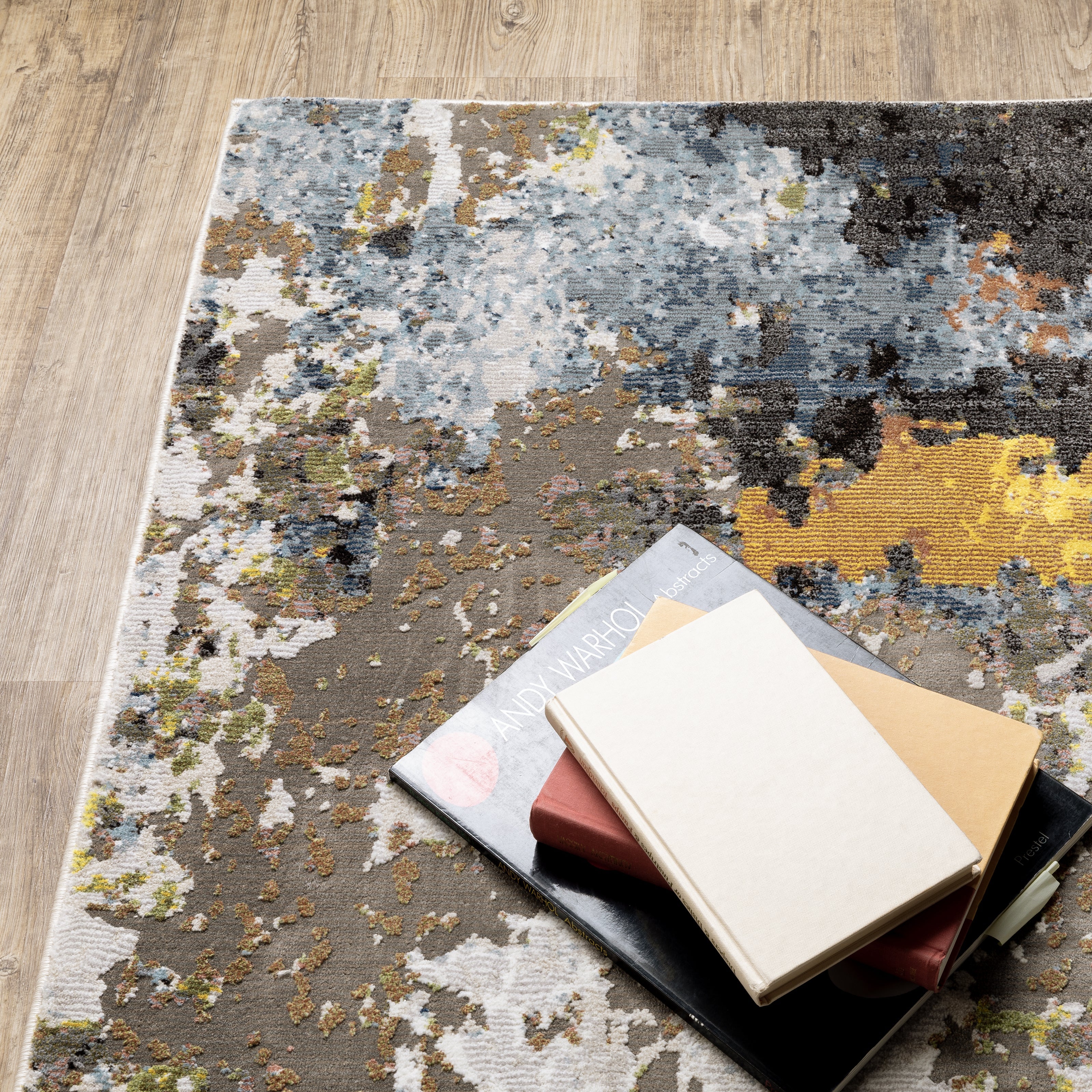 Modern abstract area rug with distressed gold, gray, and blue speckled pattern