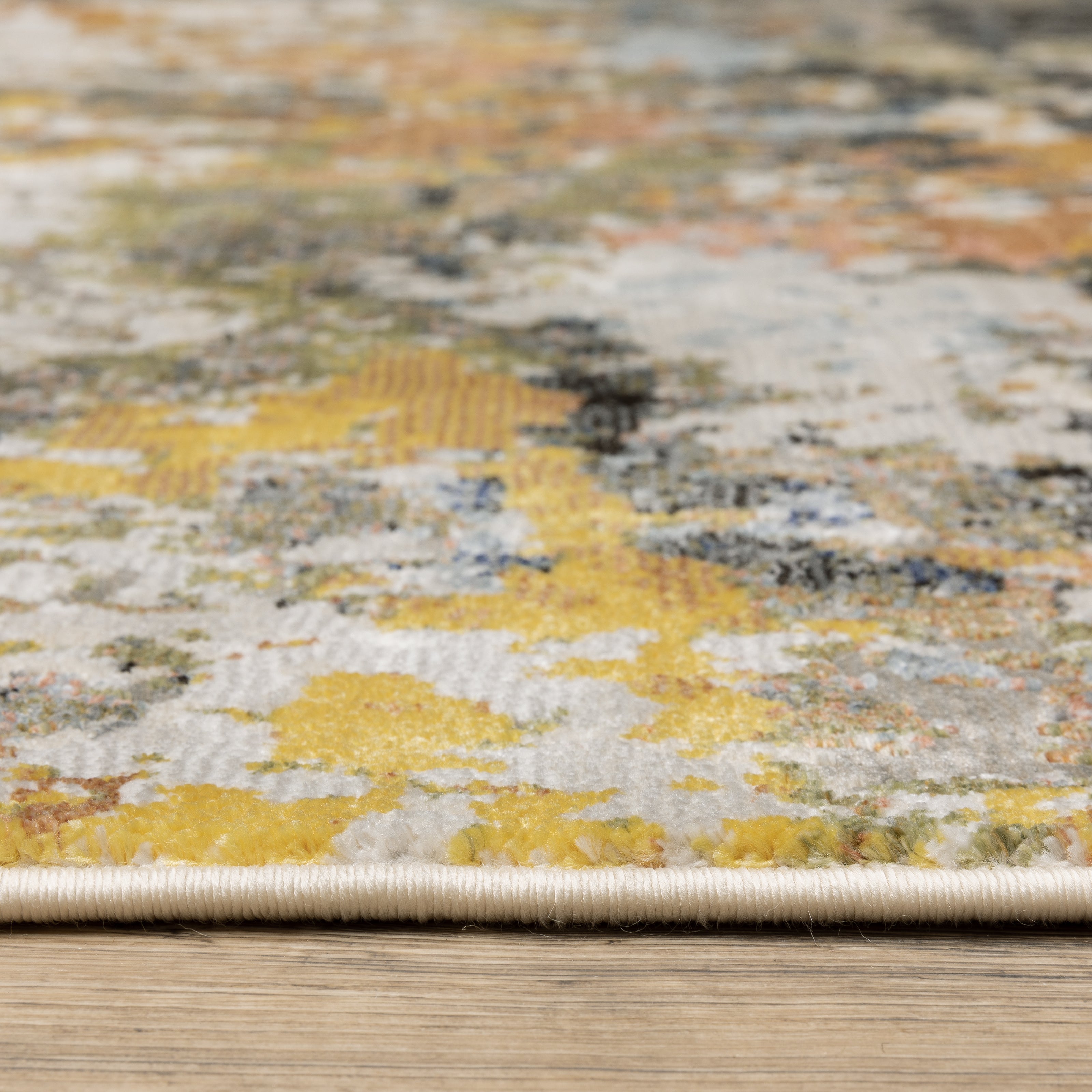 Modern abstract area rug with distressed gold, gray, and blue speckled pattern