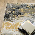 Abstract distressed rug with gold, black, and cream tones, worn texture design