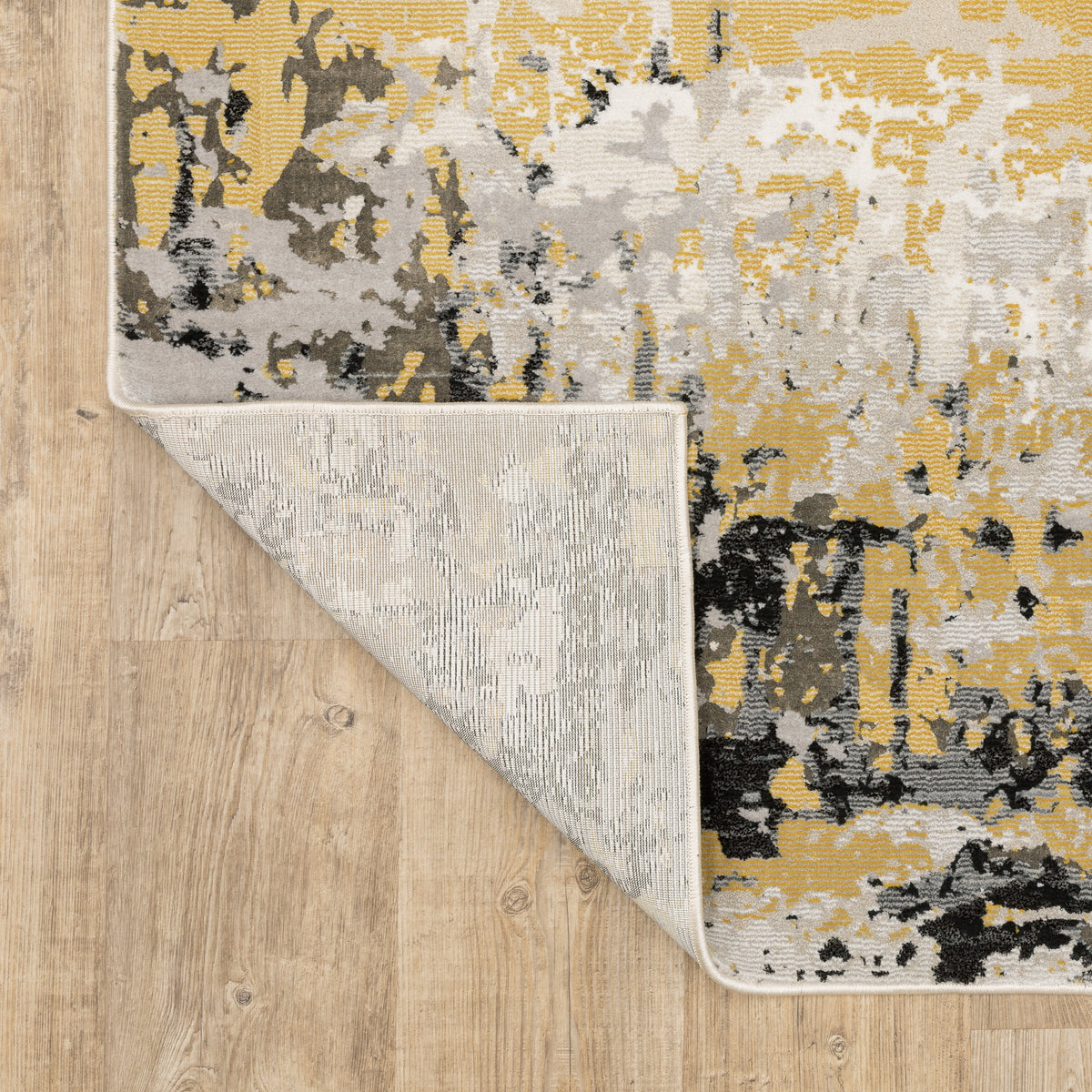 Abstract distressed rug with gold, black, and cream tones, worn texture design