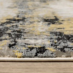 Abstract distressed rug with gold, black, and cream tones, worn texture design