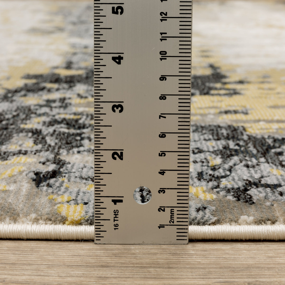 Abstract distressed rug with gold, black, and cream tones, worn texture design