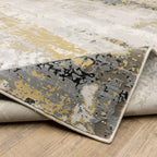 Abstract distressed rug with gold, black, and cream tones, worn texture design