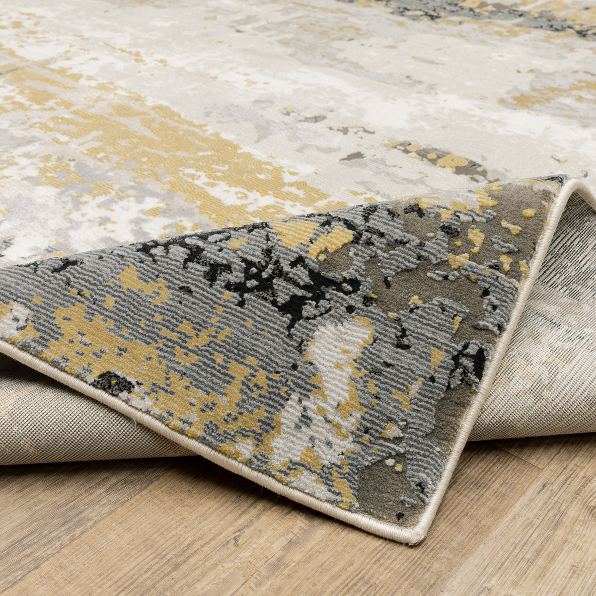Abstract distressed rug with gold, black, and cream tones, worn texture design