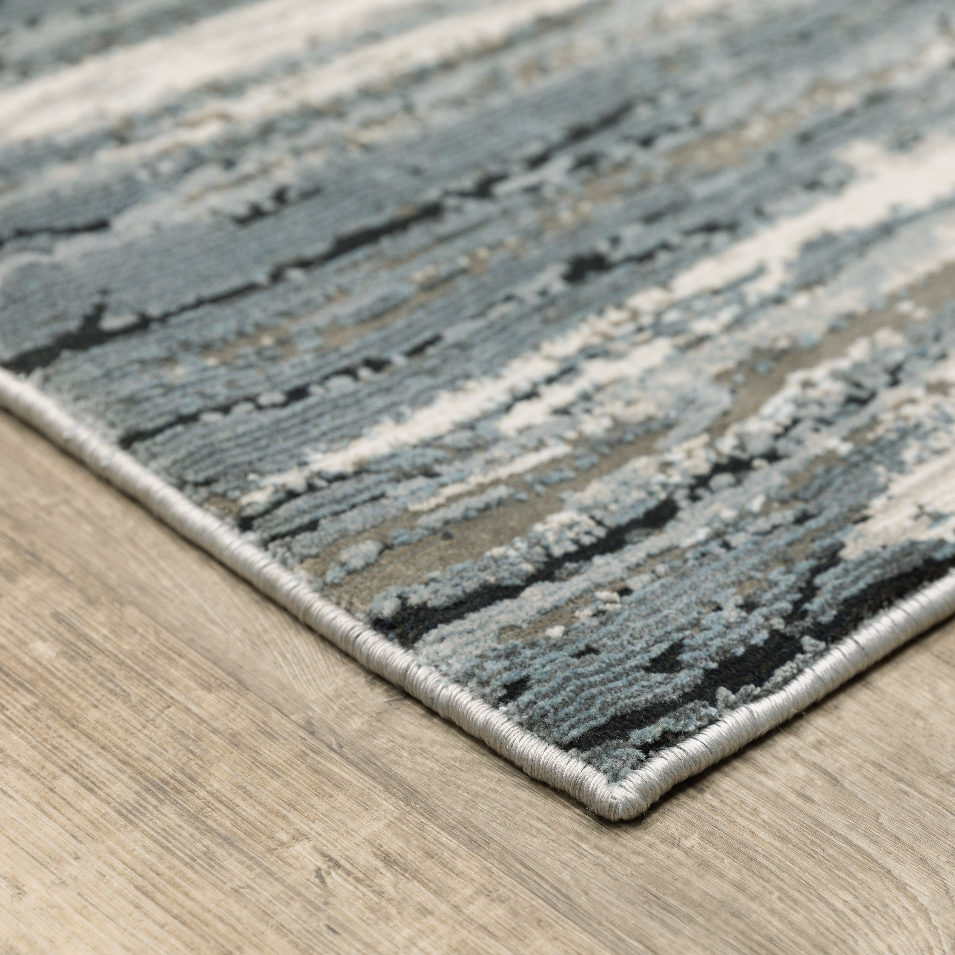 Modern grey and cream striped rug with distressed texture and abstract horizontal pattern