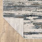 Modern grey and cream striped rug with distressed texture and abstract horizontal pattern