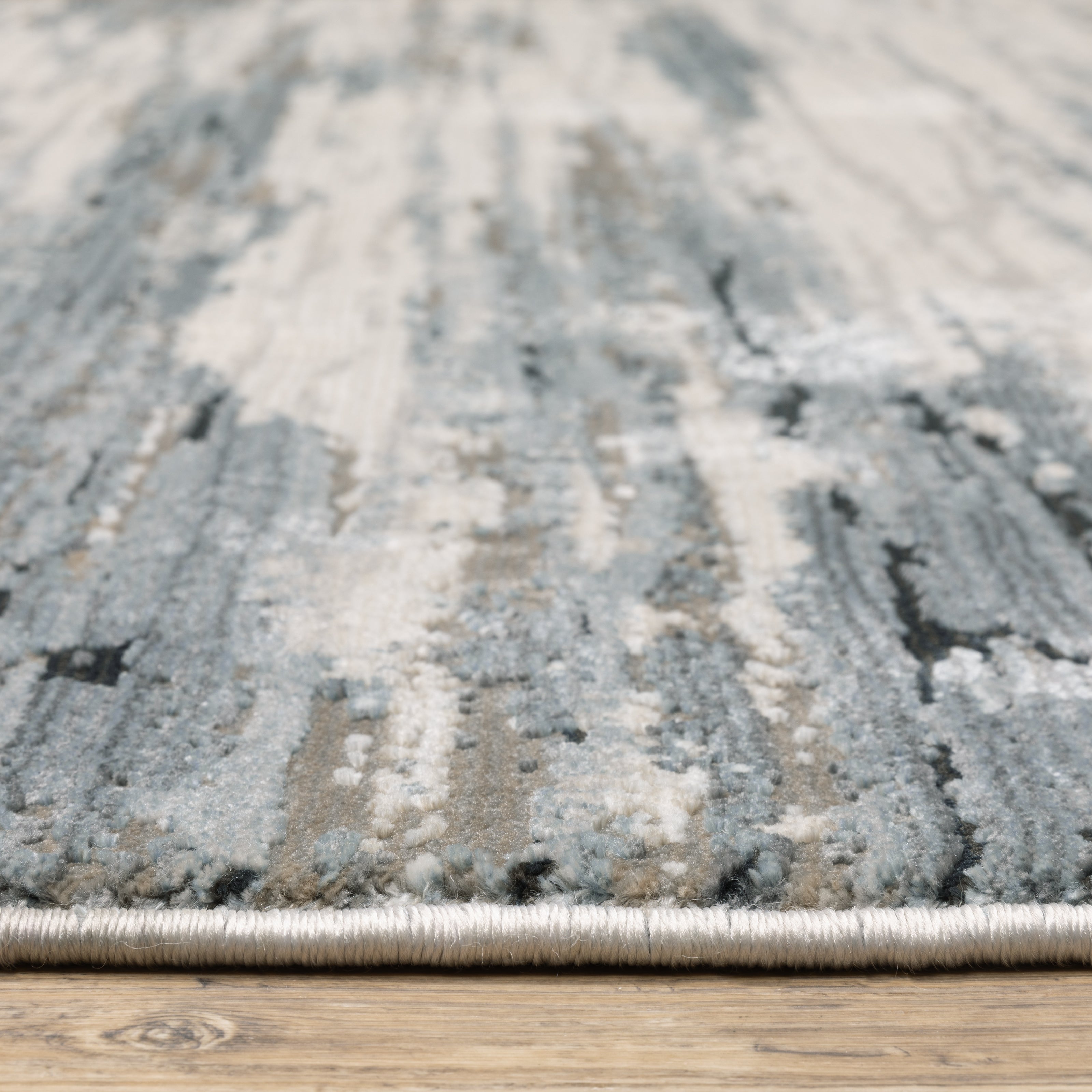 Modern grey and cream striped rug with distressed texture and abstract horizontal pattern
