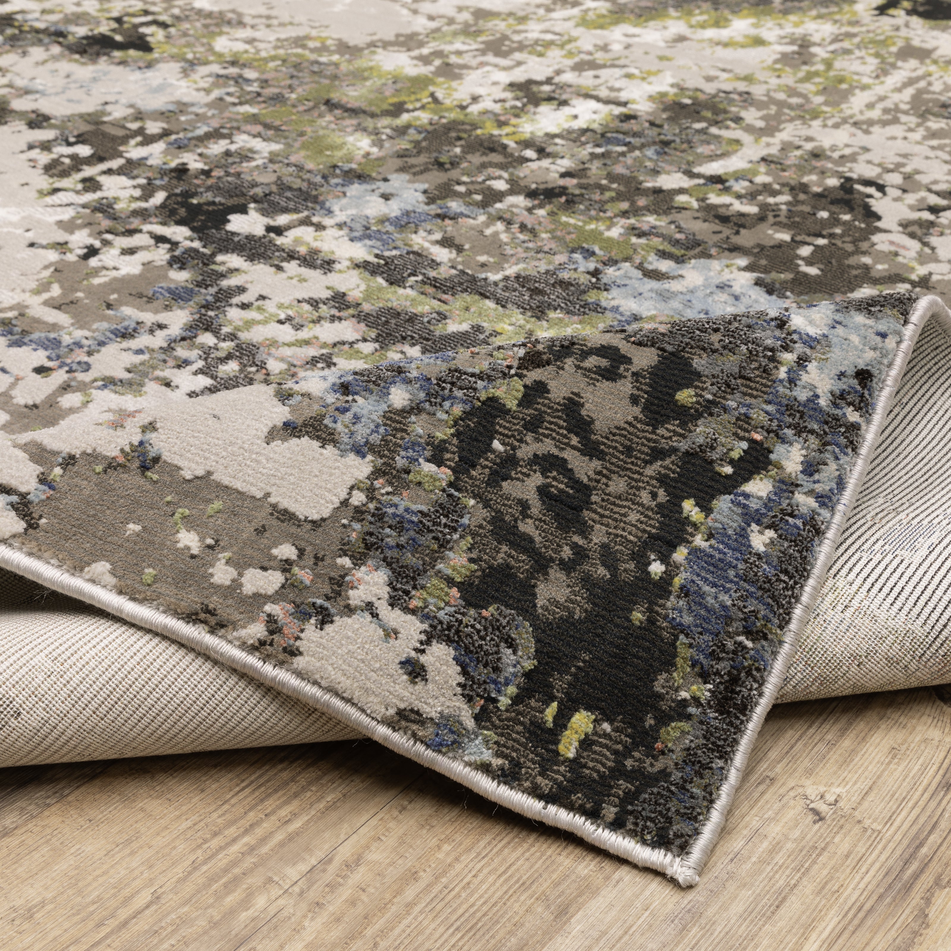 Abstract distressed area rug with grey, black, white and yellow splatter pattern