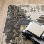 Abstract distressed area rug with grey, black, white and yellow splatter pattern