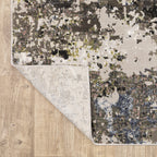 Abstract distressed area rug with grey, black, white and yellow splatter pattern