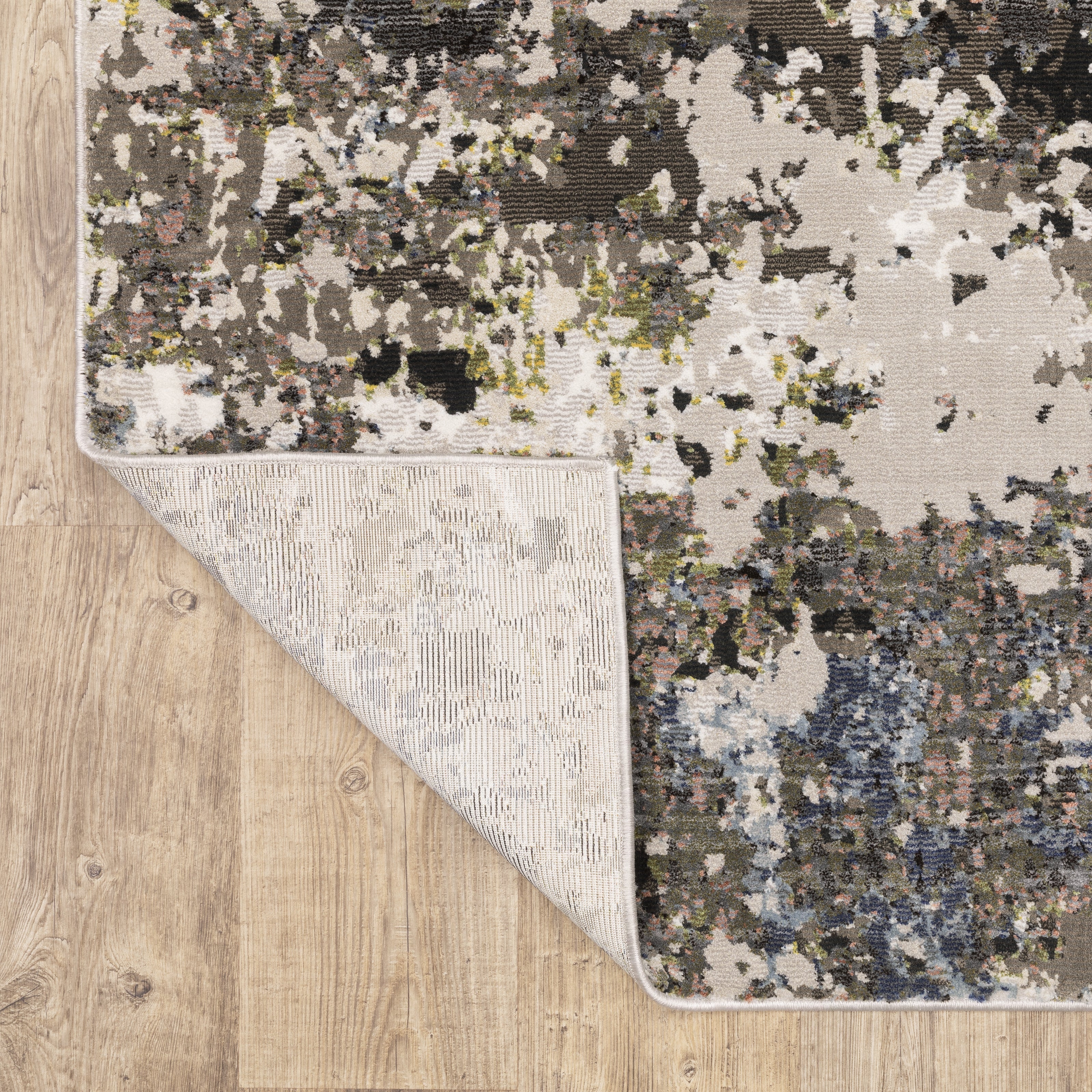 Abstract distressed area rug with grey, black, white and yellow splatter pattern