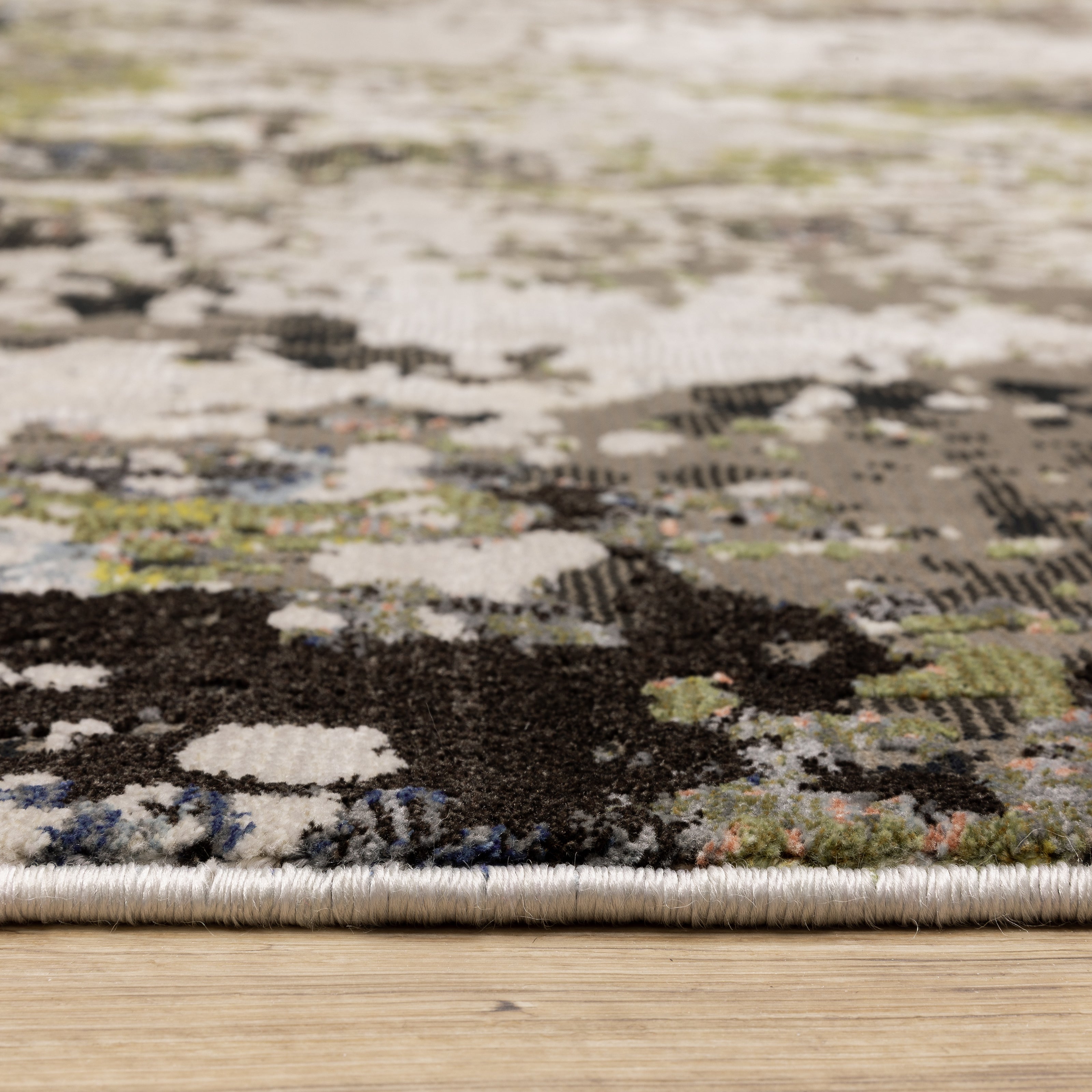 Abstract distressed area rug with grey, black, white and yellow splatter pattern