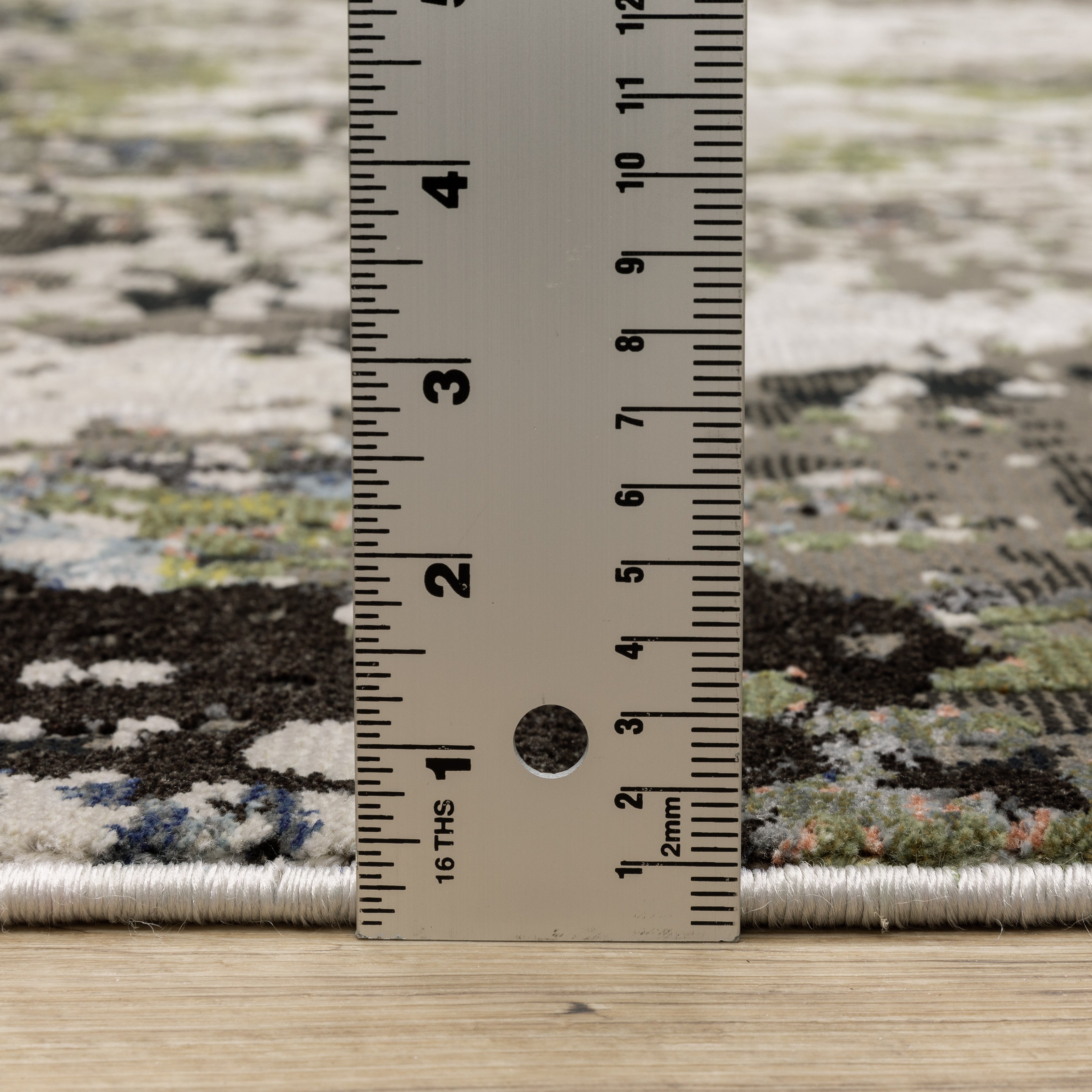 Abstract distressed area rug with grey, black, white and yellow splatter pattern