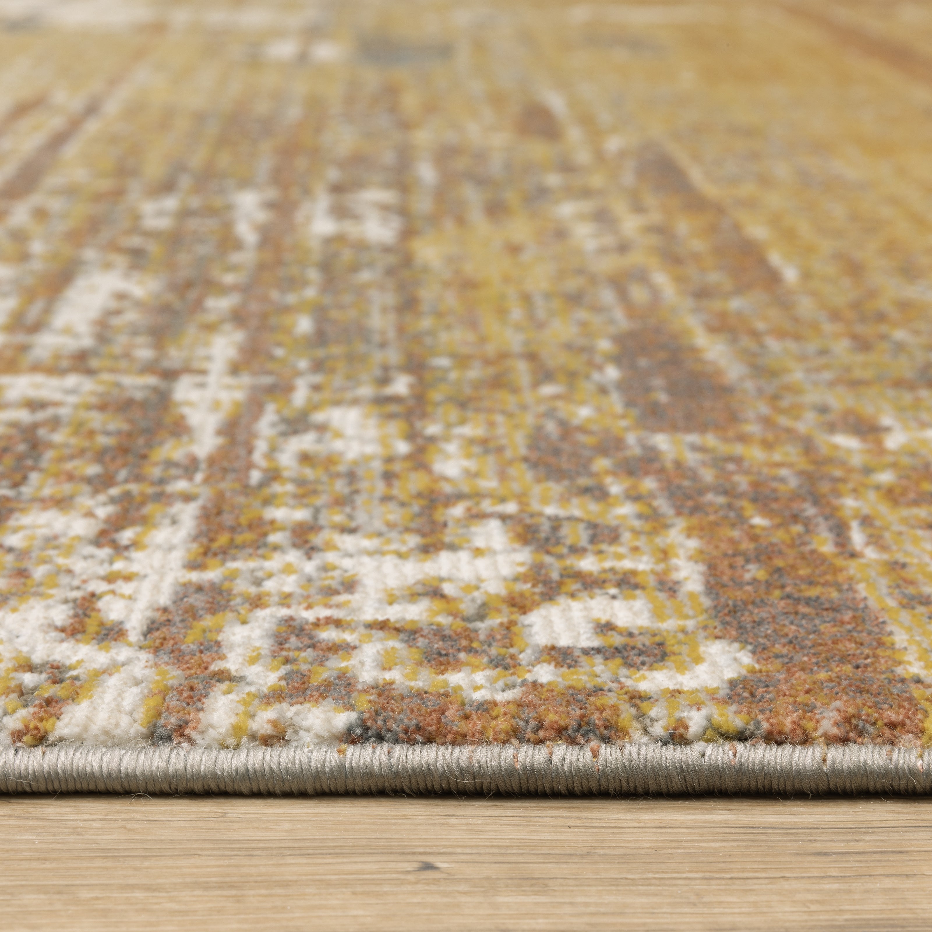Distressed gold and cream abstract rug with vintage texture and weathered pattern design