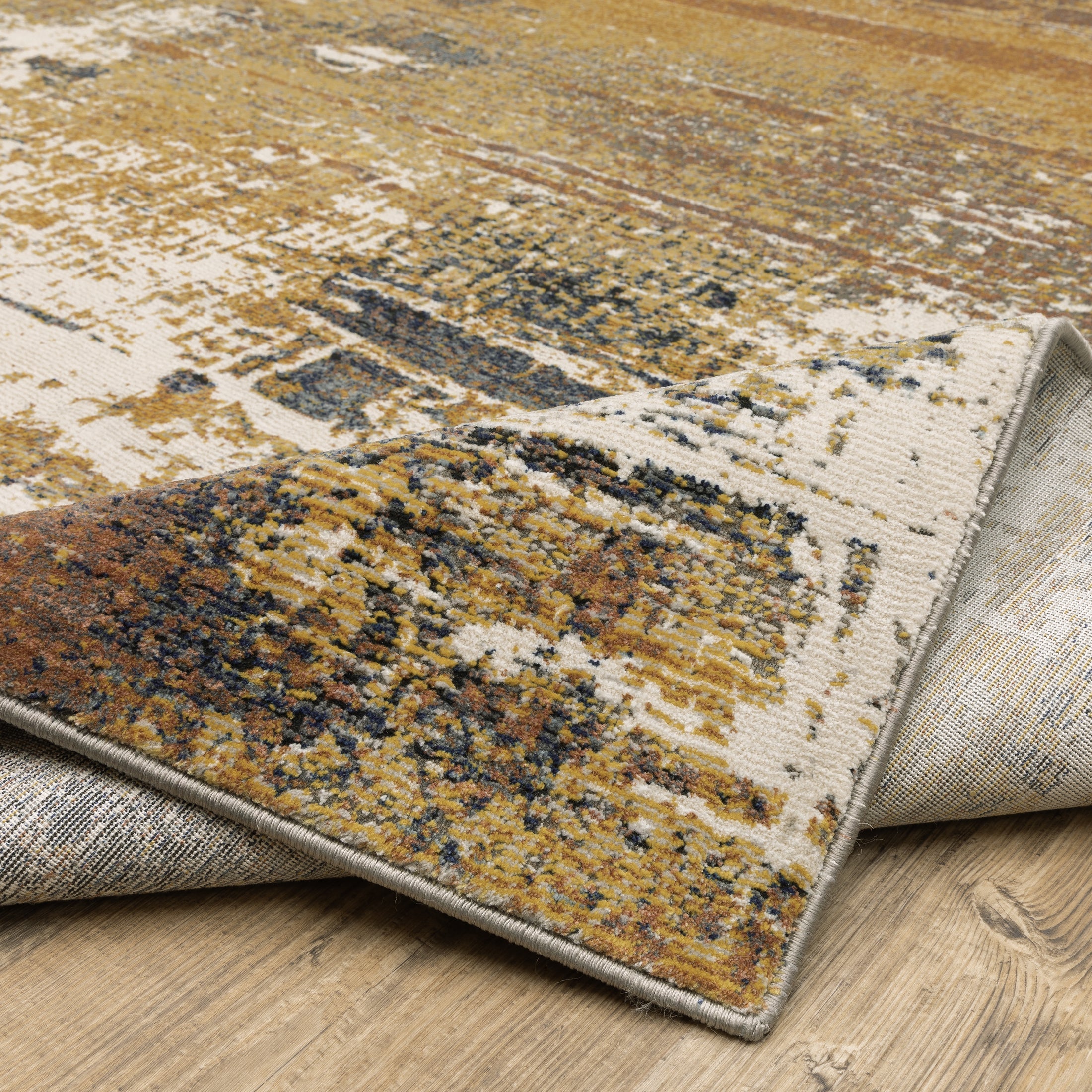 Distressed gold and cream abstract rug with vintage texture and weathered pattern design