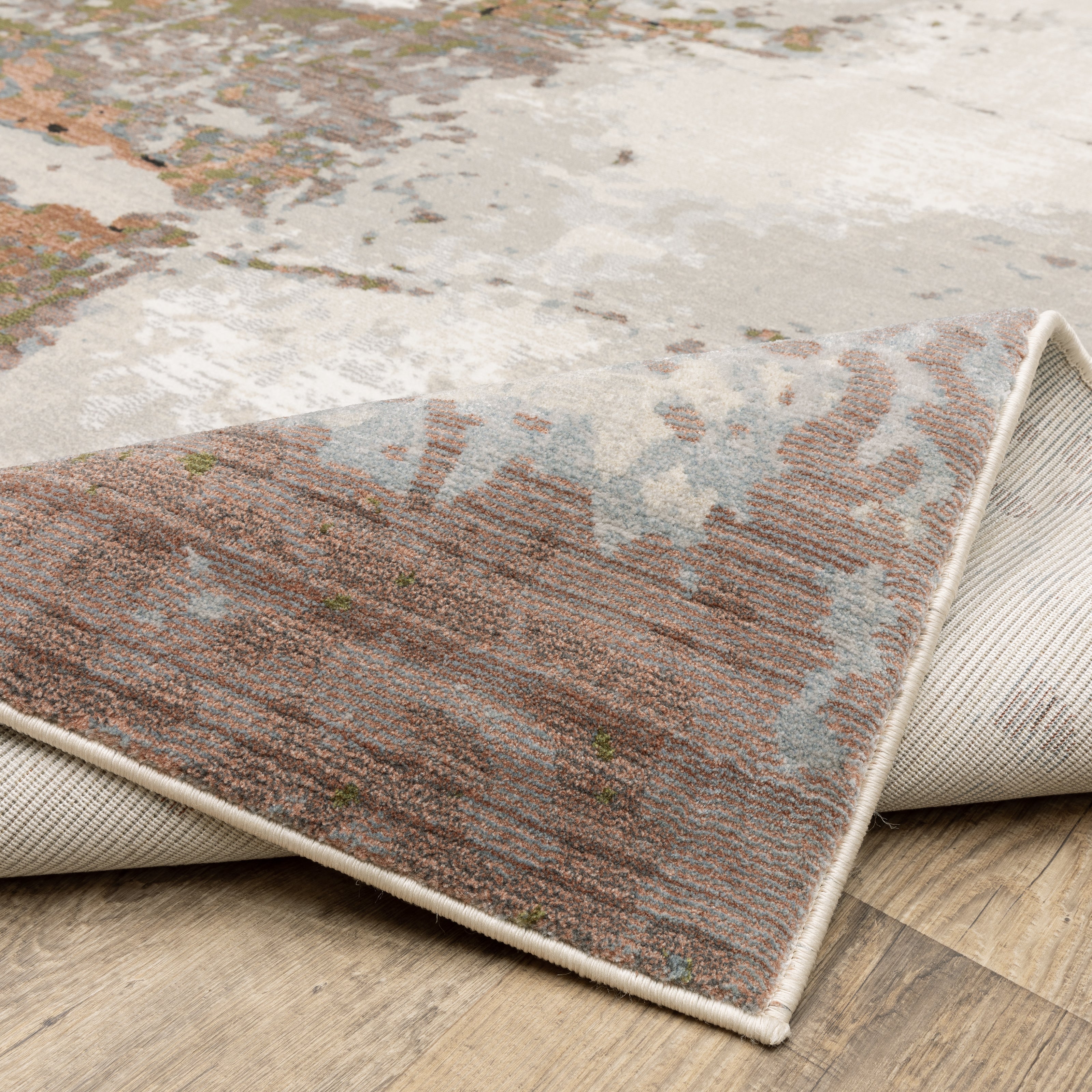Modern distressed area rug with cream, brown, and green abstract texture pattern