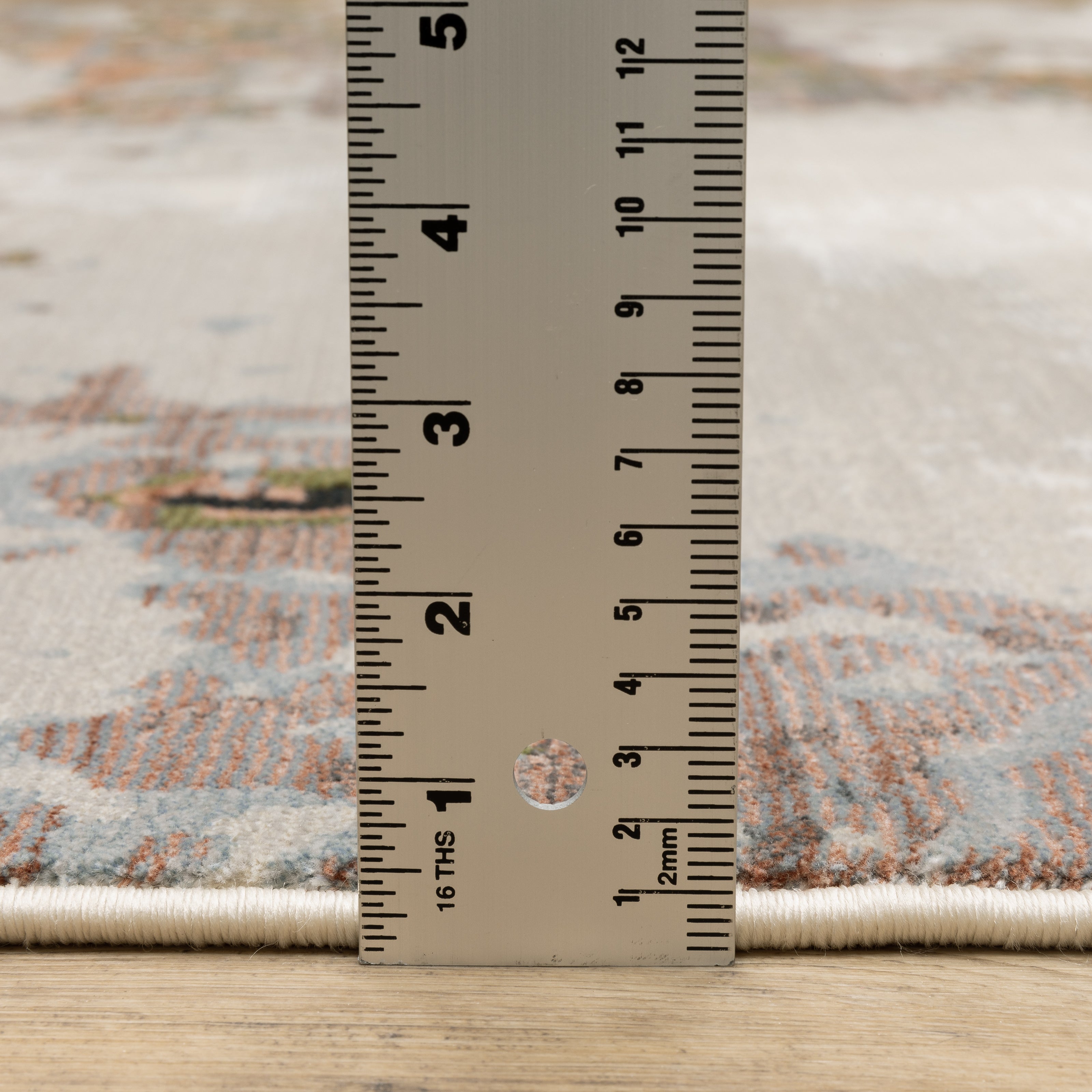 Modern distressed area rug with cream, brown, and green abstract texture pattern