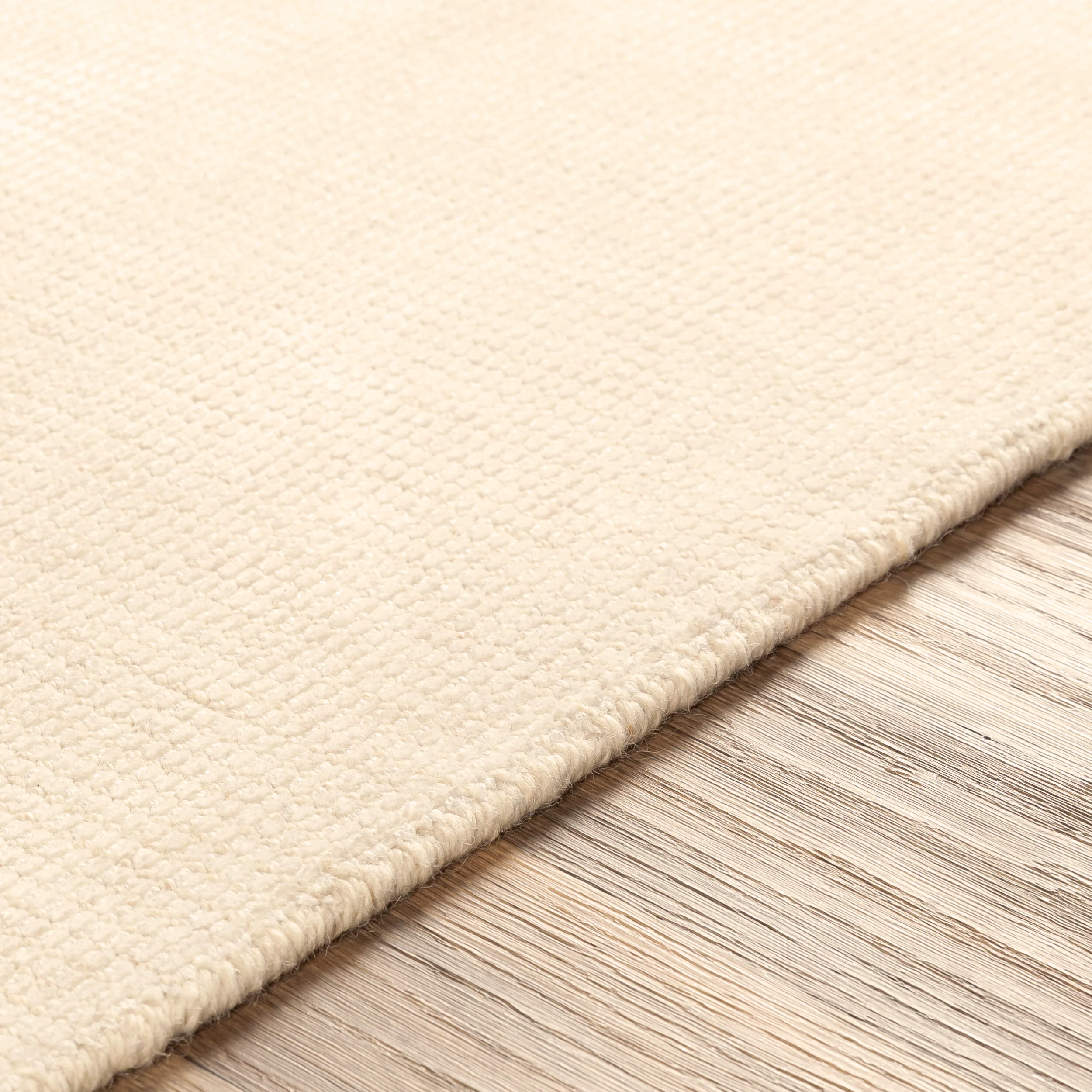 Cream colored wool rug with subtle woven texture and natural fibers